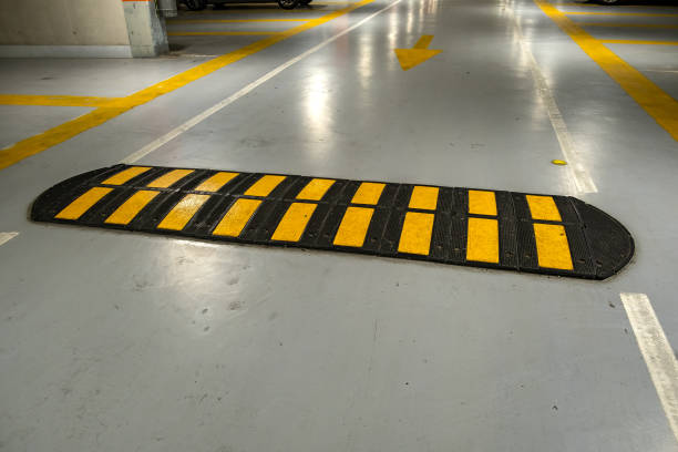 istock Striped black and yellow speed bump on a road. 1217347961