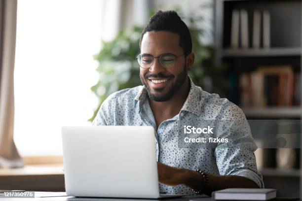 Happy African American Man Watch Funny Video On Laptop Stock Photo -  Download Image Now - iStock