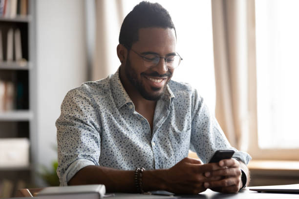 istock Smiling biracial man have fun using modern smartphone 1217350991