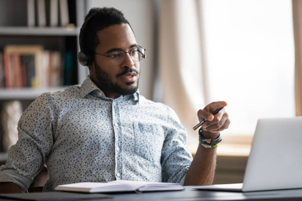 istock Focused biracial man in headphones busy working at workplace 1217351000