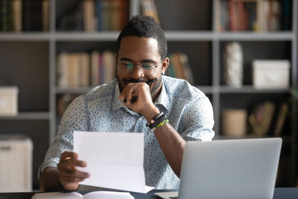 istock Pensive african American man reading letter in office 1217351026
