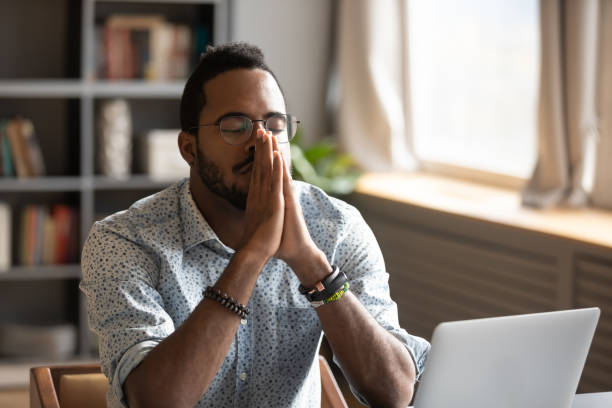 istock African American male believer pray at workplace 1217351029