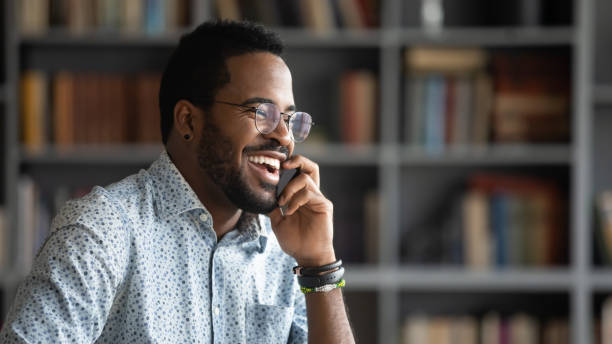istock Smiling african American man laugh talking on cellphone 1217351034