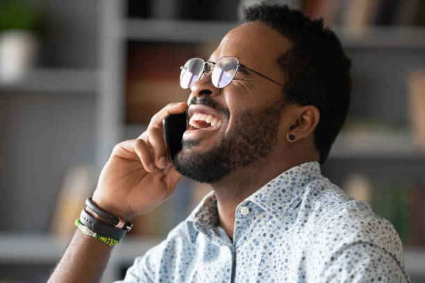 istock Overjoyed biracial man laugh talking on smartphone 1217351039