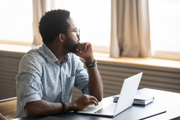 istock Pensive biracial man look in distance distracted from work 1217351040