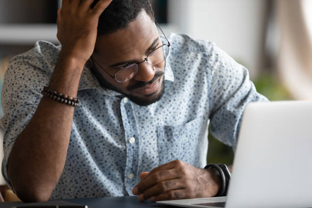 istock Frustrated african American man experience problems working on laptop 1217351059