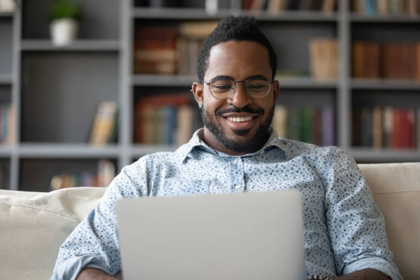 istock Smiling biracial male working on modern laptop at home 1217351103