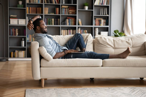 istock Smiling biracial man busy working on laptop at home 1217351105