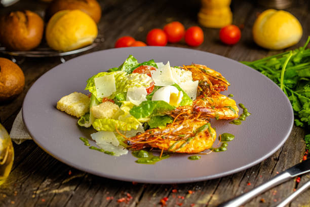 istock rustic wooden background, top and side, romaine lettuce, fried king prawns, croutons, egg 1217351112