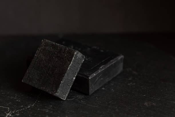 istock black carbon charcoal soap on a black stone background 1217351303