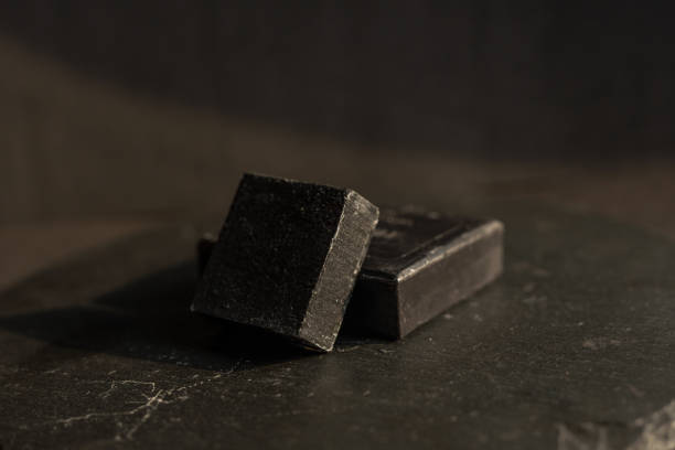istock black carbon charcoal soap on a black stone background 1217351305