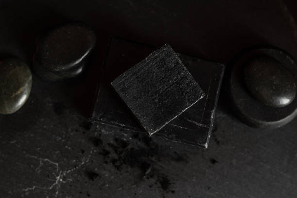 istock black carbon charcoal soap on a black stone background 1217353171