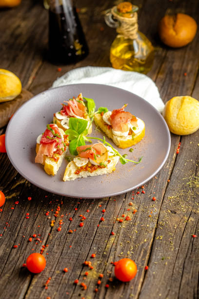 istock rustic wooden background, top and side, on a plate, appetizer sandwiches with cheese mozzarella, pork ham, greens 1217353301