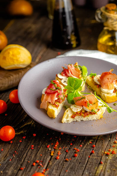 istock rustic wooden background, top and side, on a plate, appetizer sandwiches with cheese mozzarella, pork ham, greens 1217353327