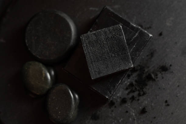 istock black carbon charcoal soap on a black stone background 1217353630