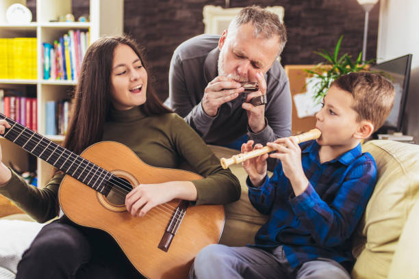 Family playing musical instruments at home having fun. Family playing musical instruments at home having fun. father and son guitar stock pictures, royalty-free photos & images