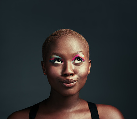 Cropped shot of a beautiful woman wearing colorful eyeshadow while posing against a grey background