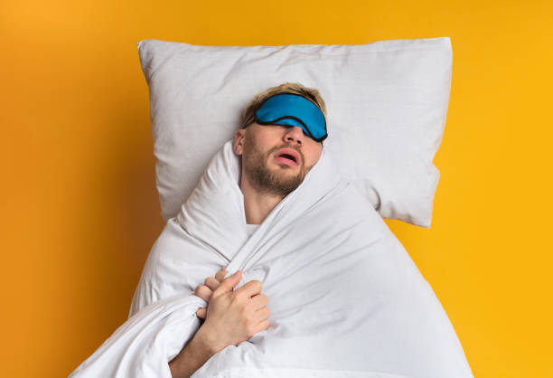 istock Sweet sleep in comfortable bed. Guy sleeps in mask 1217355219