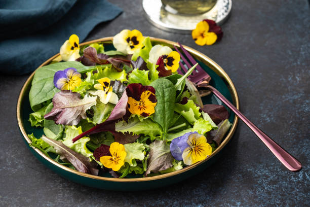 istock Spring salad with arugula, herbs and flowers. 1217355734