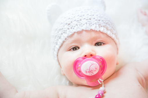 Cute Baby Girl with Pacifier Wearing a Soft Knit Bear Ears Hat
