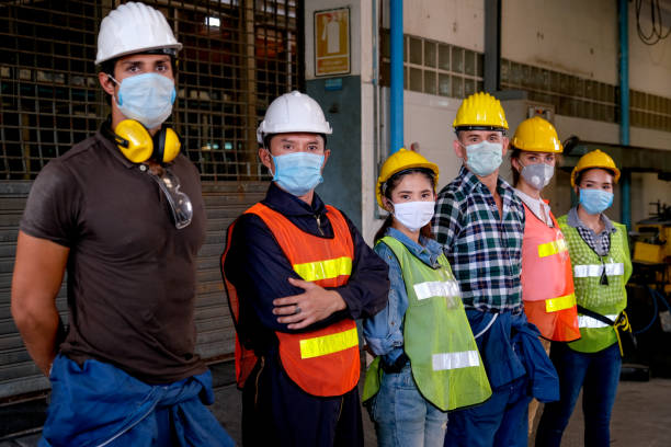 istock Group of workers or technician with mask stand and look right side direction and stay in factory area 1217361529