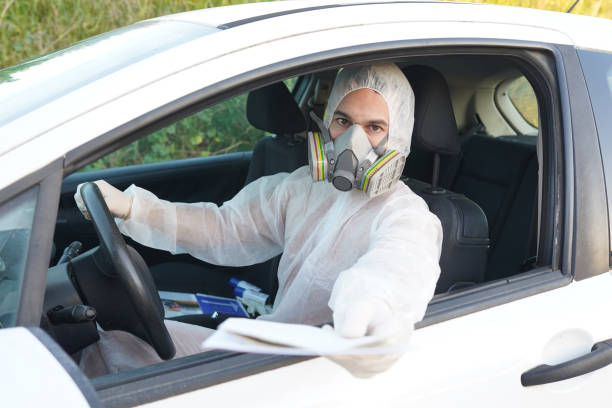 istock Dressed in full protective gear driver collects a sample from a man sitting inside his car as part of the operations of a coronavirus test 1217361774
