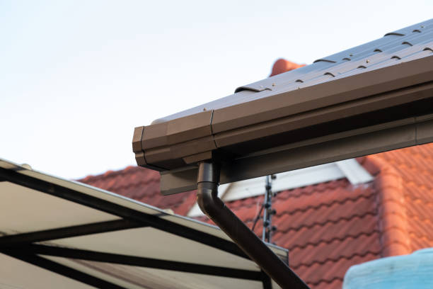 istock brown metal rain gutter and plastic pipe of house roof. 1217362019