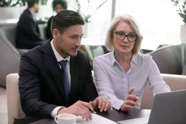 istock Focused businesspeople discuss business project using laptop 1217363311