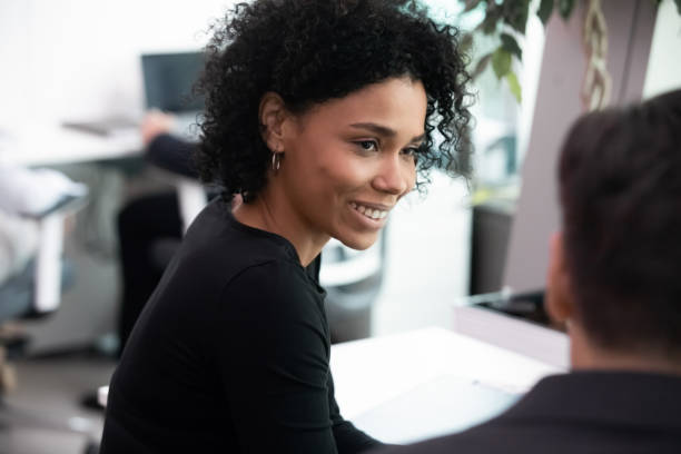 istock Smiling biracial employee talk with colleague in office 1217363355