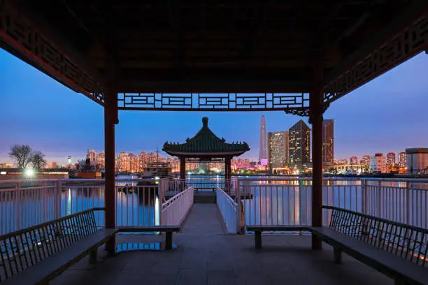 Traditional Chinese pavilions and modern buildings in the evening