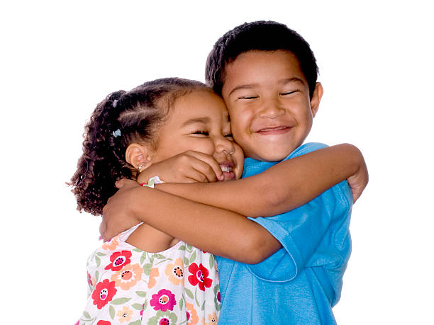 Smiling loving young boy and girl hugging. Portrait of them outside.