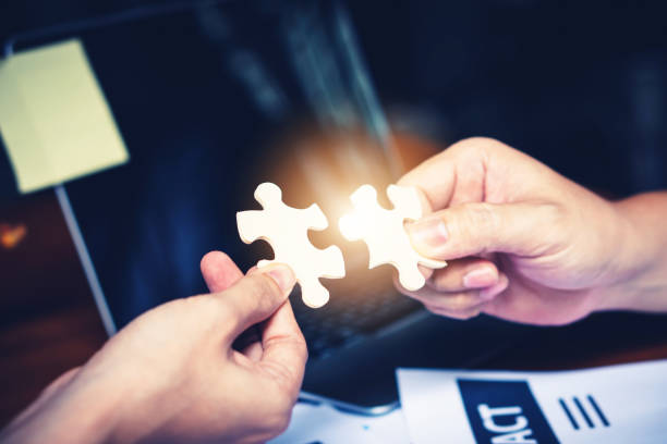 istock Partnership with puzzle jigsaw perfect fit match teamwork support build dream team. Join strategy together help safe solve crisis problem together in social distance business from coronavirus outbreak 1217365781