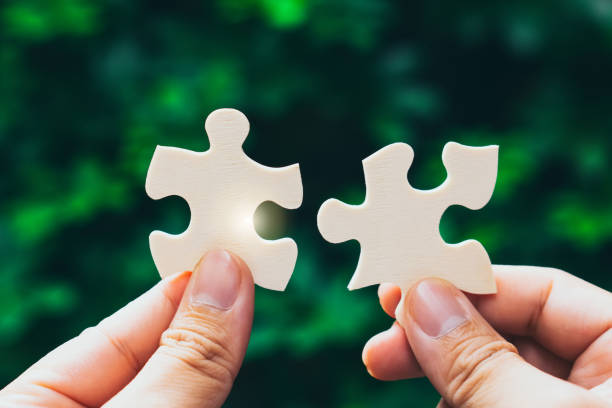 istock Partnership with puzzle jigsaw perfect fit match teamwork support build dream team. Join strategy together help safe solve crisis problem together in social distance business from coronavirus outbreak 1217365797