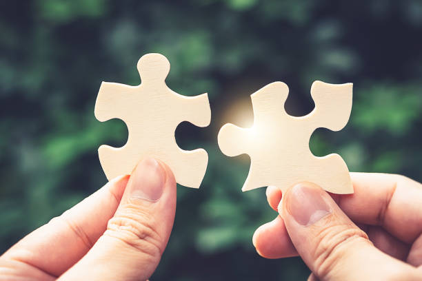 istock Partnership with puzzle jigsaw perfect fit match teamwork support build dream team. Join strategy together help safe solve crisis problem together in social distance business from coronavirus outbreak 1217365815