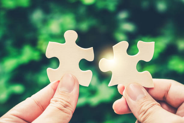 istock Partnership with puzzle jigsaw perfect fit match teamwork support build dream team. Join strategy together help safe solve crisis problem together in social distance business from coronavirus outbreak 1217365849
