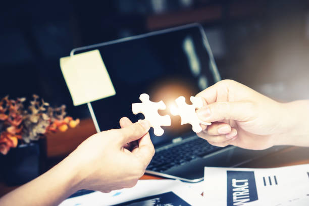 istock Partnership with puzzle jigsaw perfect fit match teamwork support build dream team. Join strategy together help safe solve crisis problem together in social distance business from coronavirus outbreak 1217365885