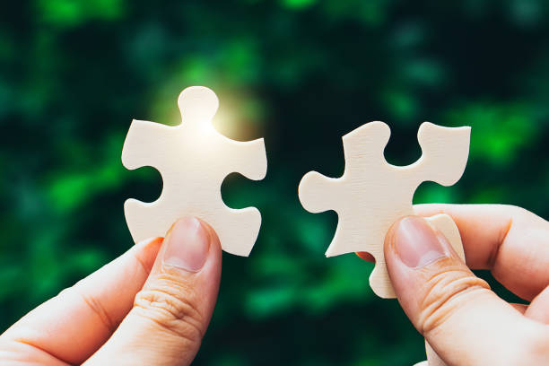 istock Partnership with puzzle jigsaw perfect fit match teamwork support build dream team. Join strategy together help safe solve crisis problem together in social distance business from coronavirus outbreak 1217365945