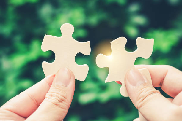 istock Partnership with puzzle jigsaw perfect fit match teamwork support build dream team. Join strategy together help safe solve crisis problem together in social distance business from coronavirus outbreak 1217365948