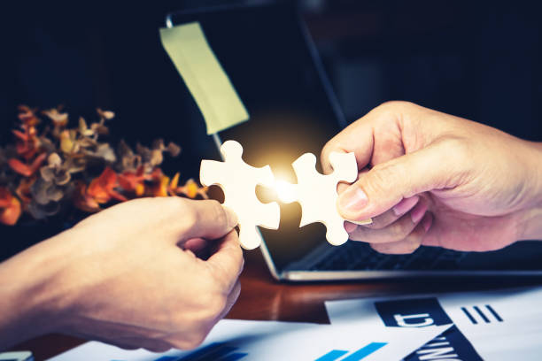 istock Partnership with puzzle jigsaw perfect fit match teamwork support build dream team. Join strategy together help safe solve crisis problem together in social distance business from coronavirus outbreak 1217366063