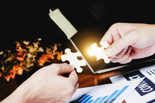 istock Partnership with puzzle jigsaw perfect fit match teamwork support build dream team. Join strategy together help safe solve crisis problem together in social distance business from coronavirus outbreak 1217366098