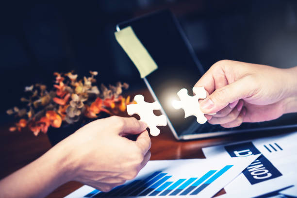istock Partnership with puzzle jigsaw perfect fit match teamwork support build dream team. Join strategy together help safe solve crisis problem together in social distance business from coronavirus outbreak 1217366142