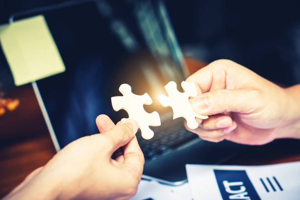 istock Partnership with puzzle jigsaw perfect fit match teamwork support build dream team. Join strategy together help safe solve crisis problem together in social distance business from coronavirus outbreak 1217366168
