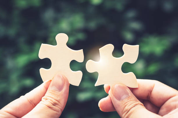 istock Partnership with puzzle jigsaw perfect fit match teamwork support build dream team. Join strategy together help safe solve crisis problem together in social distance business from coronavirus outbreak 1217366173