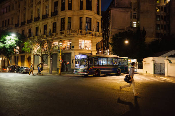 Illuminated Streets of Buenos Aires Down Town at night. Man running throw the street. Street Photo. Bus. Rushing.