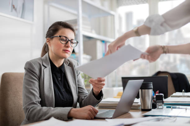istock Manager giving feedback to young employee on her draft document. Ambitious young woman working in a busy office downtown. 1217368240