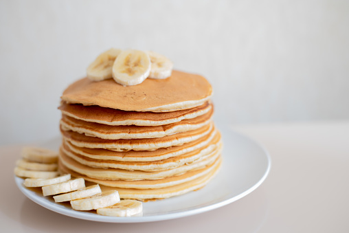 Healthy breakfast,homemade classic american pancakes with fresh banana slices. Food photography.