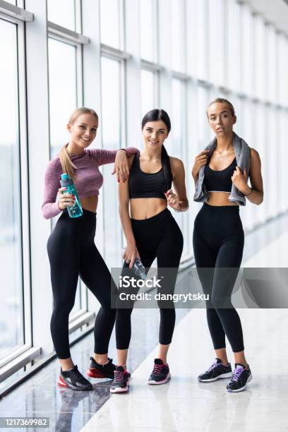 Three young fitness girls holding yoga mat while standing in gym Stock  Photo - Alamy