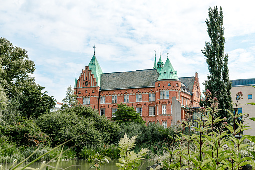 Malmö, Sweden - July 19, 2019: The old castle like building is housing the city library. It stands in the middle of a green park called Slottsparken and Kungsparken