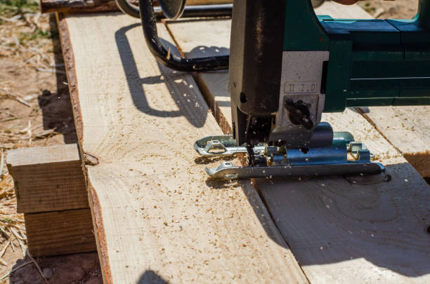 istock worker sawing boards with a jigsaw at a construction site and sawdust fly 1217371147
