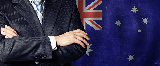 Male hands against Australian flag background, business, politics and education in Australia